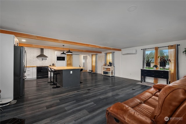 living room featuring beam ceiling, dark hardwood / wood-style flooring, and a wall unit AC