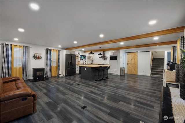 living room featuring dark hardwood / wood-style flooring, a barn door, and sink