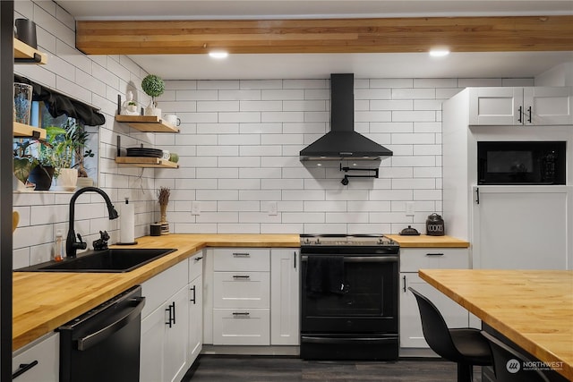 kitchen featuring butcher block countertops, wall chimney exhaust hood, and black appliances