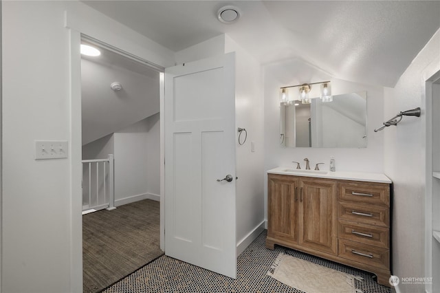 bathroom with vanity and vaulted ceiling