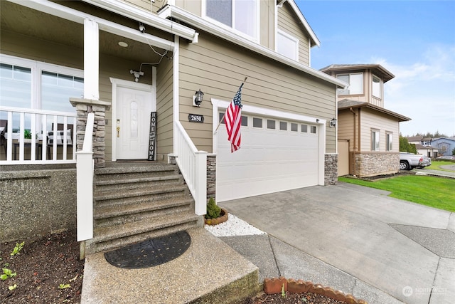 property entrance featuring stone siding, driveway, and an attached garage