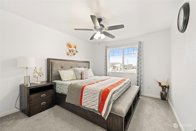 bedroom with light colored carpet, ceiling fan, and baseboards