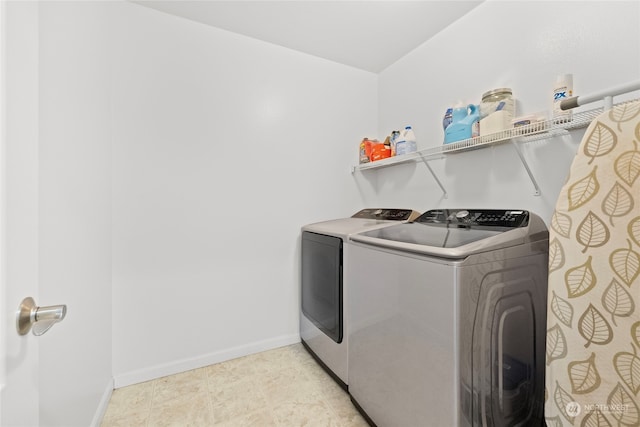 laundry room with laundry area, washing machine and dryer, and baseboards