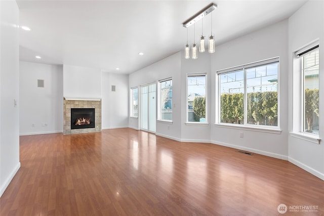 unfurnished living room with baseboards, wood finished floors, visible vents, and recessed lighting