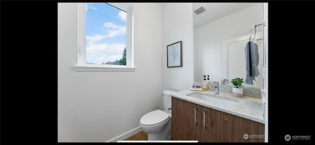 bathroom featuring toilet, vanity, and hardwood / wood-style flooring