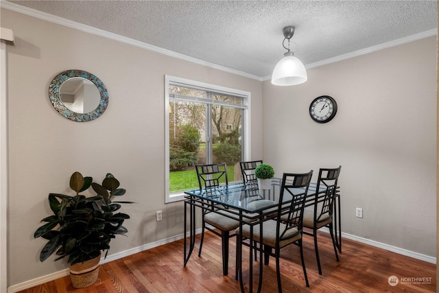 dining room featuring dark wood-type flooring, a wealth of natural light, ornamental molding, and a textured ceiling