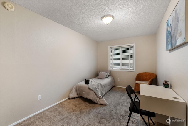 bedroom featuring a textured ceiling and light carpet