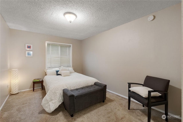 bedroom featuring a textured ceiling and light colored carpet