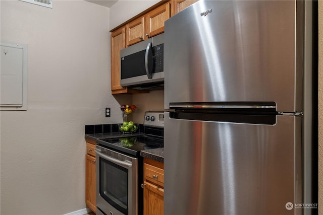 kitchen featuring stainless steel appliances and dark stone countertops