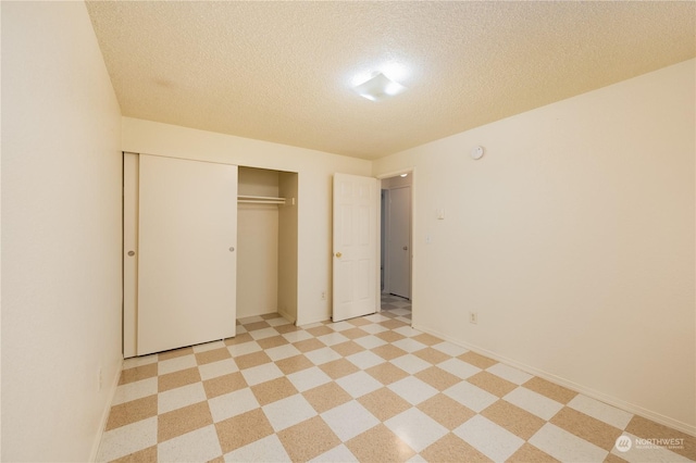 unfurnished bedroom with a textured ceiling and a closet