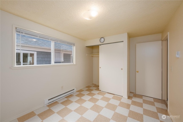 unfurnished bedroom with a textured ceiling, a baseboard radiator, and a closet