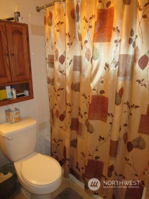 bathroom with toilet and curtained shower