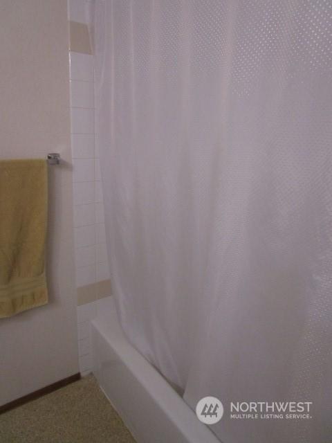 bathroom with shower / bath combo with shower curtain