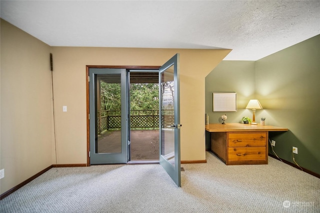 doorway featuring a textured ceiling, light carpet, and french doors