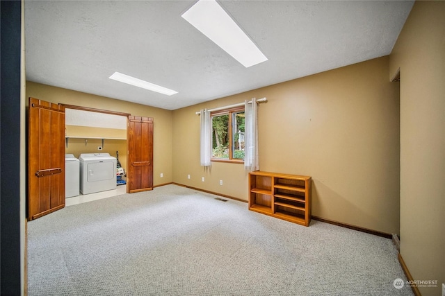 carpeted empty room featuring washer and dryer