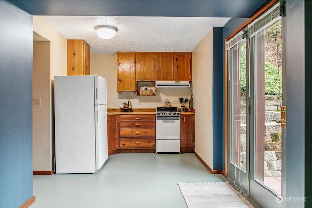 kitchen featuring a textured ceiling, white appliances, and ventilation hood