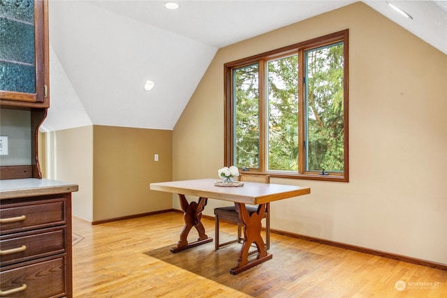 dining area featuring light hardwood / wood-style floors and vaulted ceiling