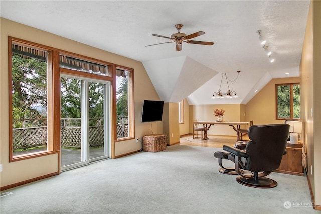 sitting room with a textured ceiling, light carpet, ceiling fan with notable chandelier, and lofted ceiling