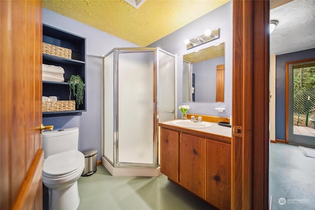 bathroom featuring vanity, toilet, a shower with door, and a textured ceiling