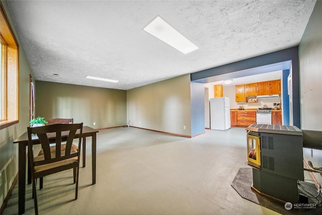 interior space with a wood stove and a textured ceiling