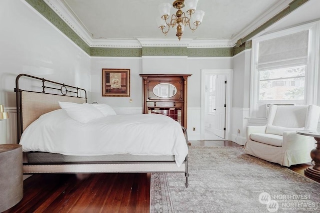 bedroom with hardwood / wood-style flooring, crown molding, and a chandelier