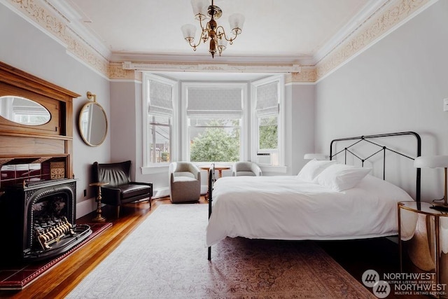 bedroom featuring a notable chandelier, hardwood / wood-style floors, and crown molding