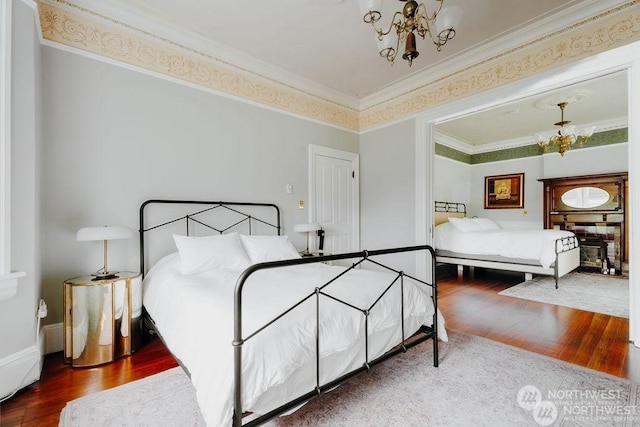 bedroom featuring ornamental molding, a notable chandelier, and hardwood / wood-style flooring