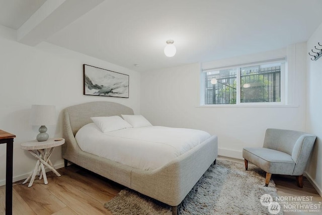 bedroom featuring beam ceiling and wood-type flooring