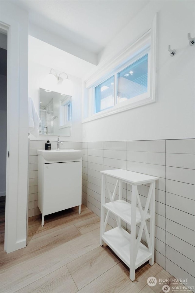 bathroom featuring hardwood / wood-style floors, tile walls, and vanity