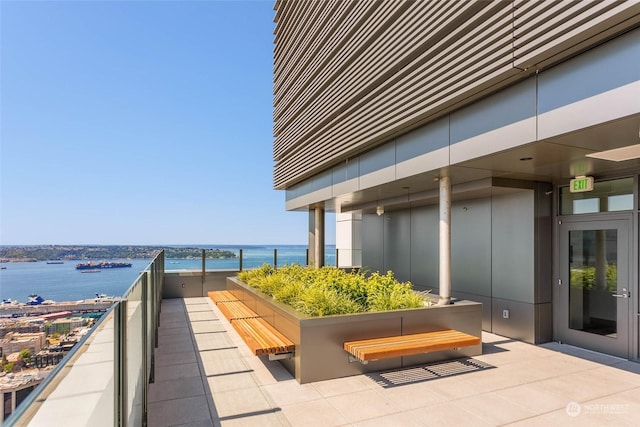 view of patio featuring a water view and a balcony