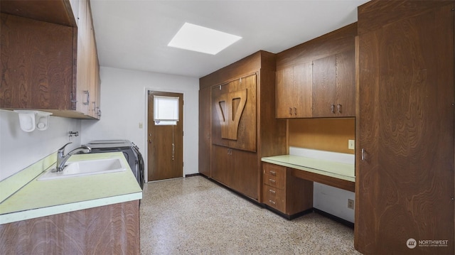 laundry area with a skylight, sink, and cabinets