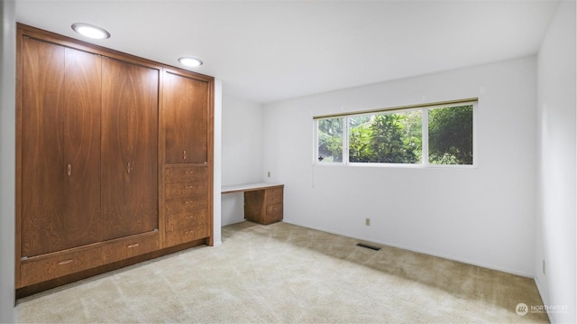 unfurnished bedroom featuring a closet and light colored carpet