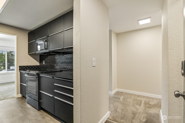 kitchen with electric stove, light carpet, and backsplash