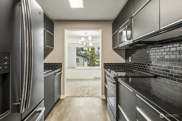 kitchen featuring hanging light fixtures, stainless steel appliances, tasteful backsplash, light colored carpet, and a chandelier