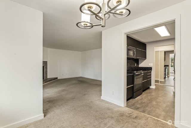 kitchen featuring backsplash, hanging light fixtures, a notable chandelier, range with electric stovetop, and light colored carpet