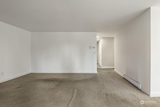 empty room with carpet floors and a baseboard heating unit