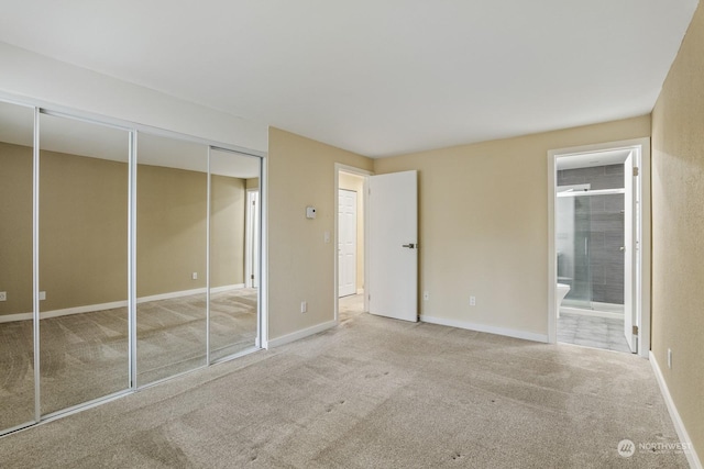 unfurnished bedroom featuring ensuite bathroom and carpet flooring