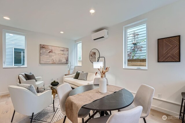 dining space featuring light hardwood / wood-style flooring and a wall mounted air conditioner