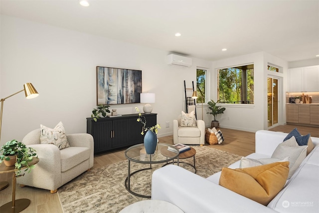 living room with a wall mounted air conditioner and light hardwood / wood-style floors