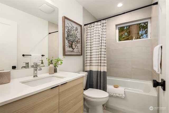 full bathroom featuring vanity, shower / tub combo, and toilet