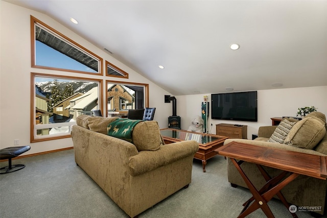 carpeted living room with lofted ceiling, a healthy amount of sunlight, and a wood stove