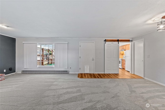 carpeted spare room featuring a barn door and a baseboard radiator