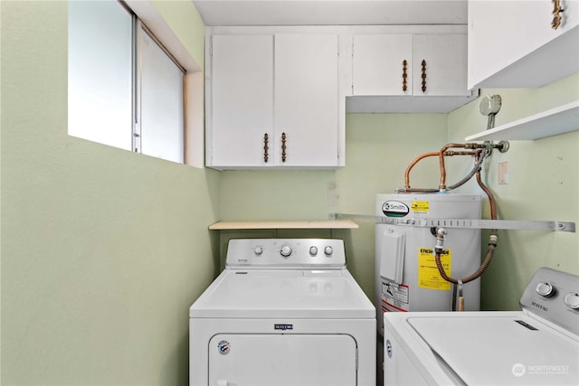 laundry room with cabinets, washing machine and dryer, and electric water heater