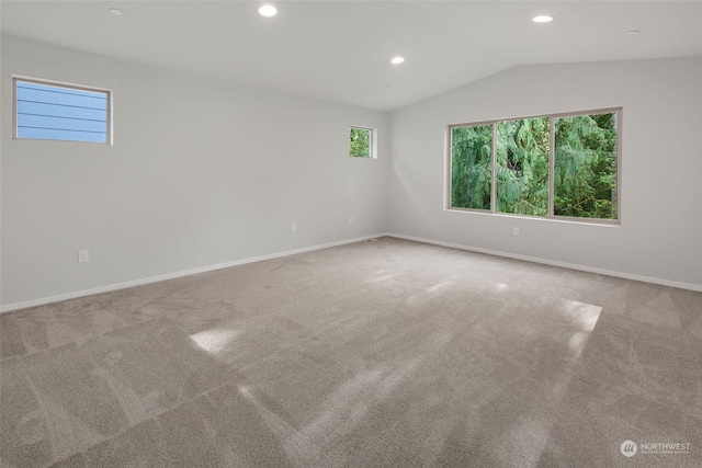 carpeted empty room featuring lofted ceiling