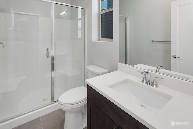 bathroom featuring tile patterned flooring, vanity, toilet, and an enclosed shower