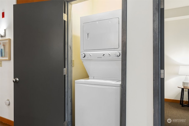 washroom featuring carpet flooring and stacked washer / dryer