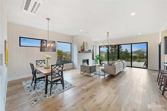 dining space with light wood-type flooring and a fireplace