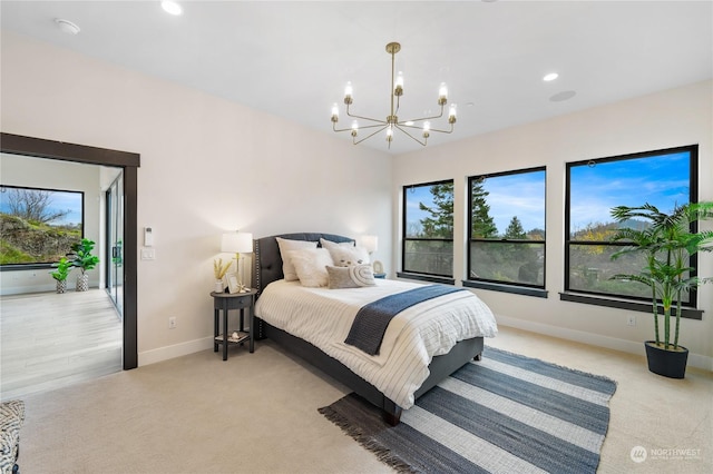 bedroom featuring a chandelier, light carpet, and multiple windows