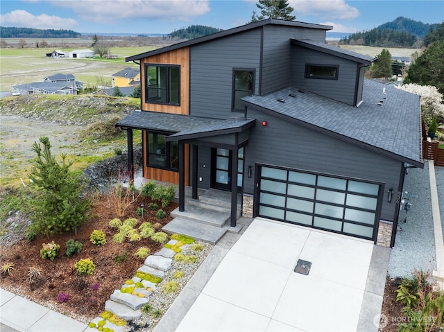 506 High St, La Conner, WA 98257 - contemporary house with stone siding, a shingled roof, and driveway