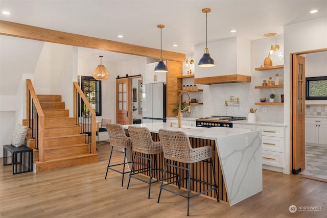 kitchen with decorative light fixtures, white cabinets, white refrigerator, and a barn door